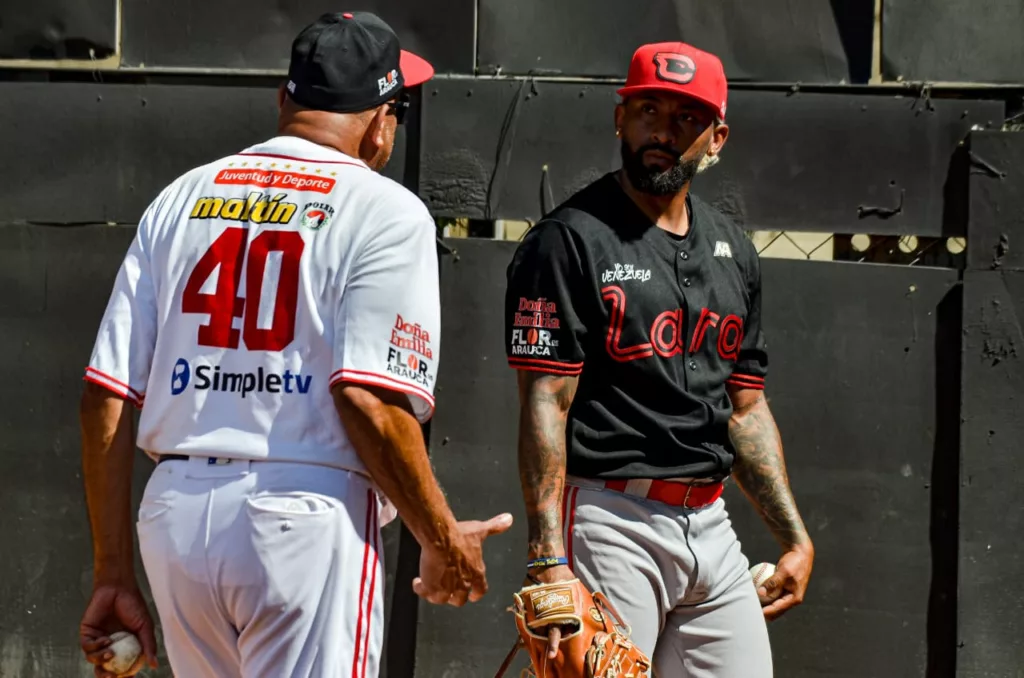 Yapson Gómez habla con el coach de bullpen Oswald Peraza