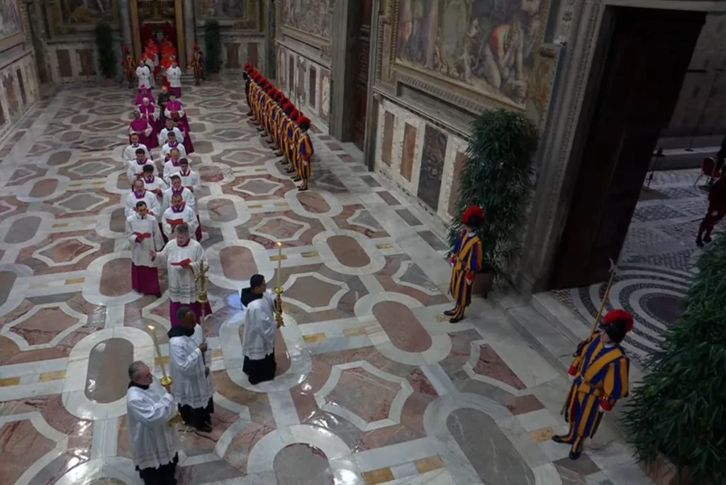 A las 16:30 hora de roma, los cardenales entraron solemnemente en la Capilla Sixtina, entonando la meditativa Letanía de los Santos y el himno latino Veni Creator, implorando a los santos y al Espíritu Santo que les ayuden a elegir un Papa, seguido de oraciones, procedido luego del juramento colectivo y posterior el juramento individual