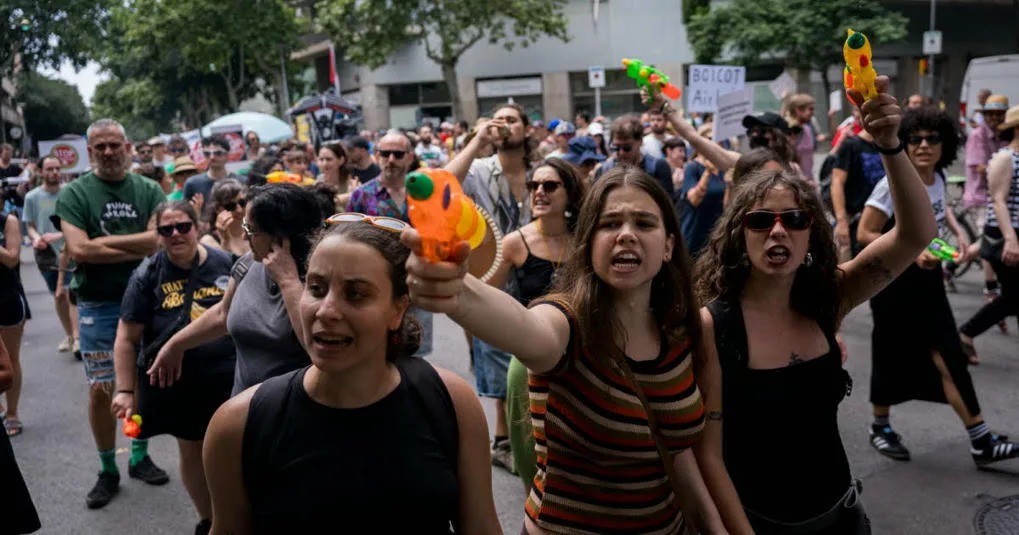 Manifestantes españoles usaron pistolas de agua contra turistas desprevenidos el domingo en Barcelona y Mallorca, mientras marchaban para exigir que se reconsidere un modelo económico que creen que está alimentando una crisis de vivienda y eliminando el carácter de sus ciudades natales.